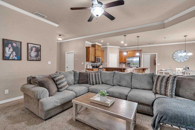 living area with light colored carpet, ceiling fan with notable chandelier, visible vents, baseboards, and ornamental molding