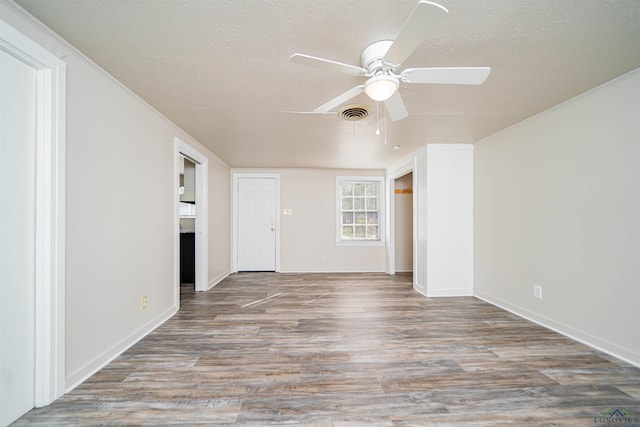 206 Empire St, Gladewater, TX 75647 - spare room featuring a ceiling fan, wood finished floors, and a textured ceiling