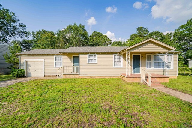 206 Empire St, Gladewater, TX 75647 - single story home featuring a garage, a porch, a front yard, and asphalt driveway