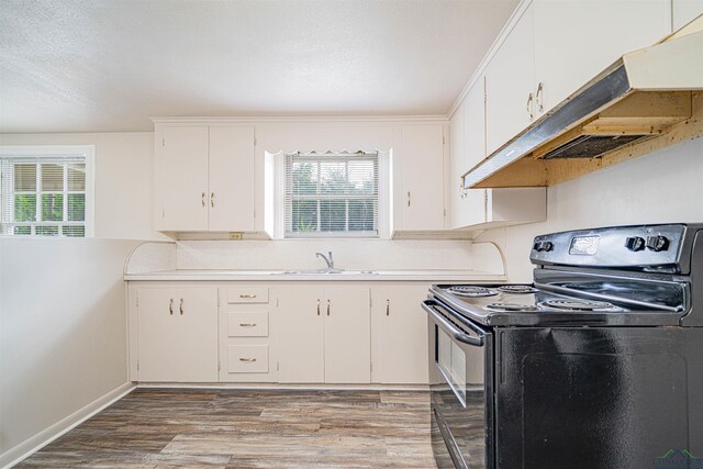 206 Empire St, Gladewater, TX 75647 - kitchen with black range with electric cooktop, under cabinet range hood, light countertops, and healthy amount of natural light