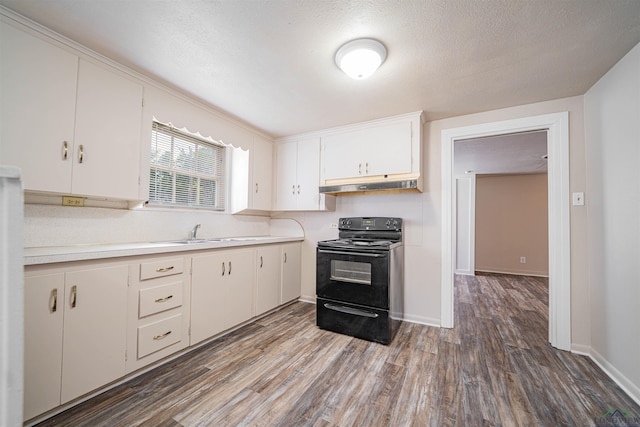 206 Empire St, Gladewater, TX 75647 - kitchen featuring black range with electric cooktop, light countertops, wood finished floors, under cabinet range hood, and white cabinetry