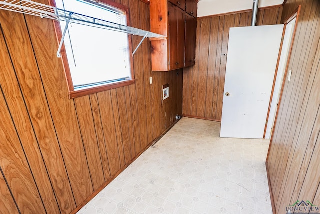 laundry room with washer hookup, plenty of natural light, and wood walls