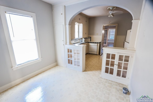 kitchen featuring sink, white appliances, white cabinets, and ceiling fan