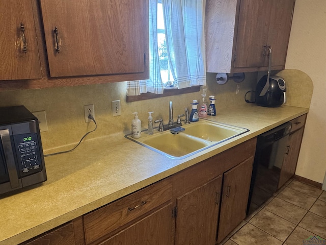 kitchen with dishwasher, light countertops, a sink, and light tile patterned flooring