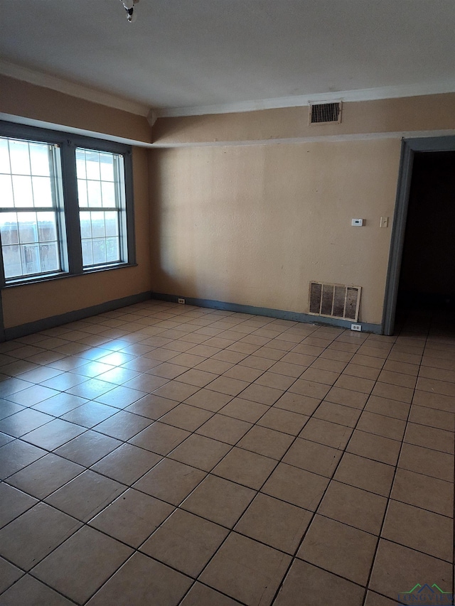 spare room featuring light tile patterned flooring and ornamental molding