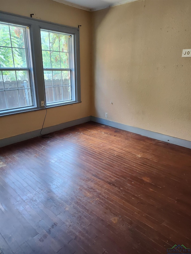 unfurnished room featuring dark hardwood / wood-style flooring and plenty of natural light