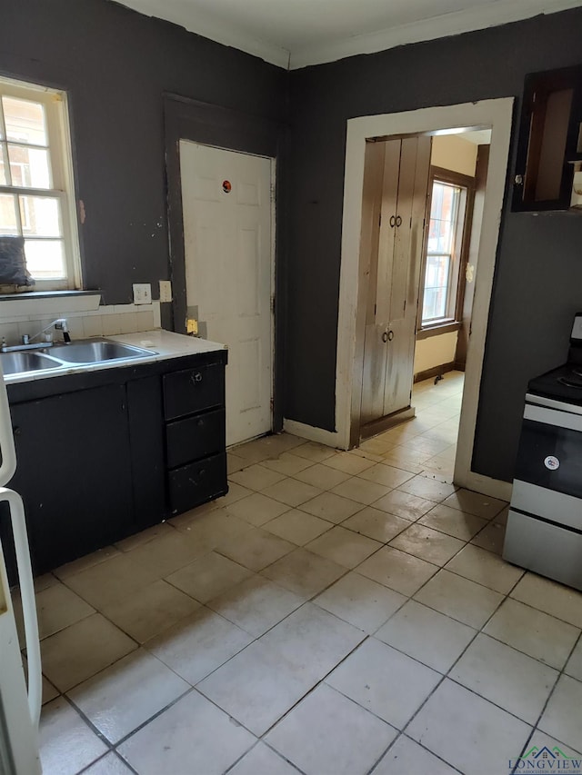 kitchen featuring electric range, sink, and light tile patterned flooring