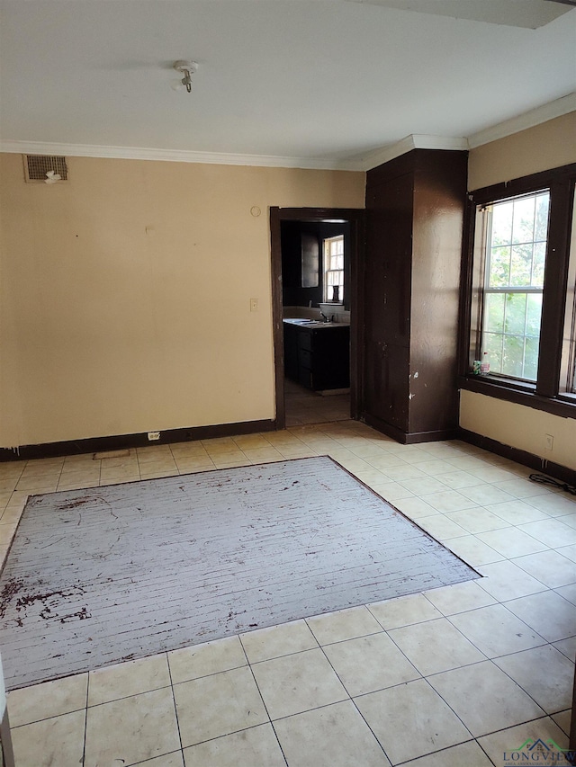 tiled spare room featuring crown molding and sink