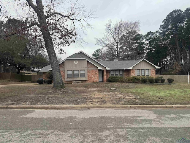 view of front of house featuring fence and brick siding