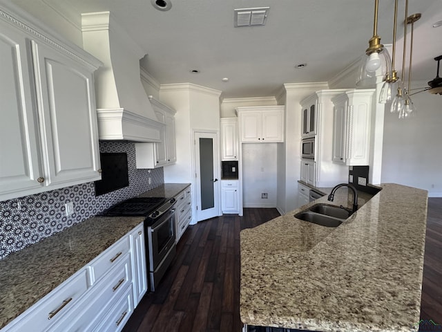 kitchen featuring white cabinets, hanging light fixtures, sink, decorative backsplash, and appliances with stainless steel finishes