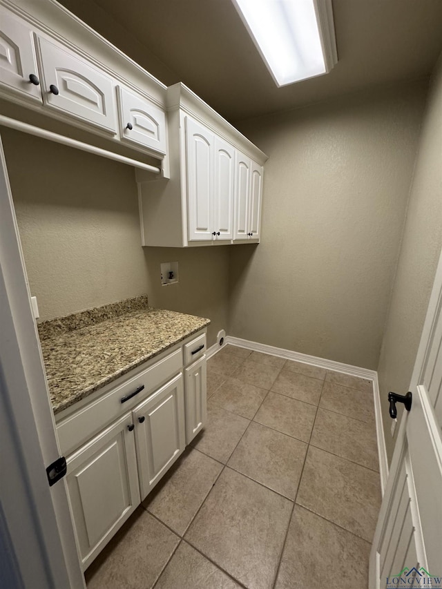 laundry room featuring light tile patterned flooring, cabinets, and hookup for a washing machine