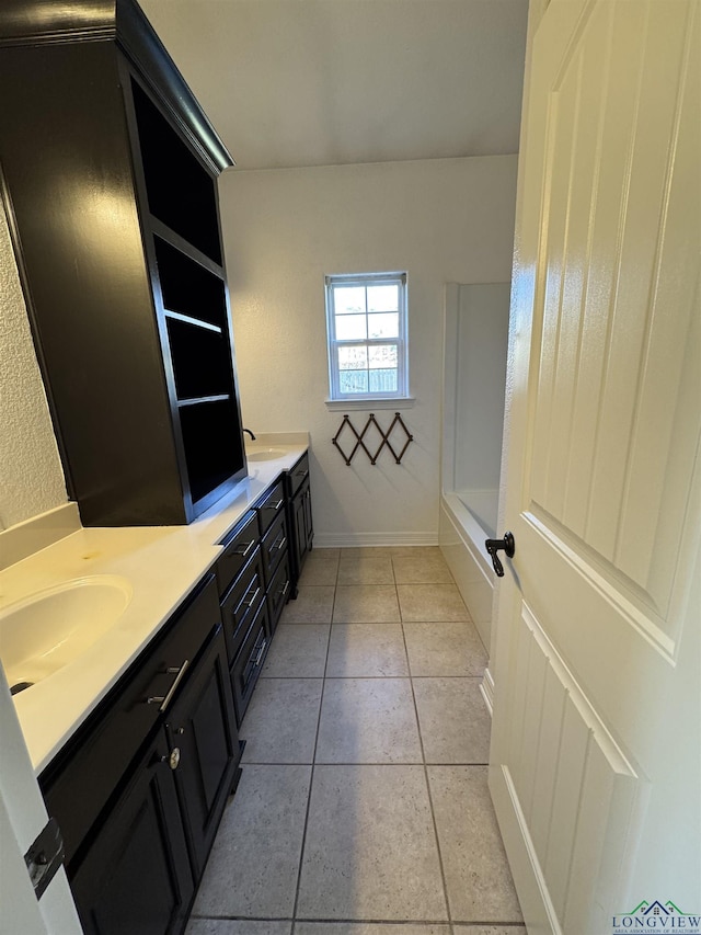 bathroom featuring tile patterned floors, vanity, and a bathing tub