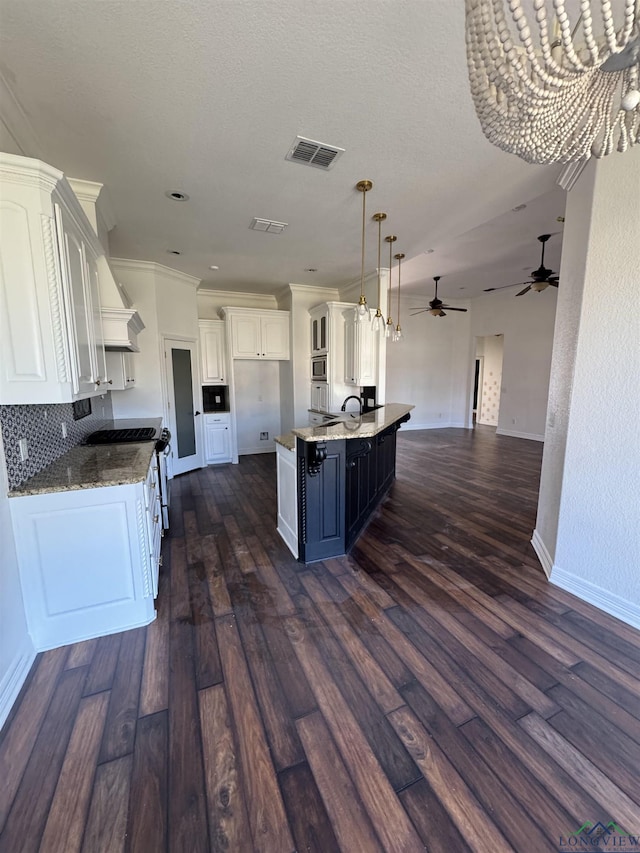 kitchen featuring pendant lighting, dark hardwood / wood-style floors, white cabinetry, and a large island