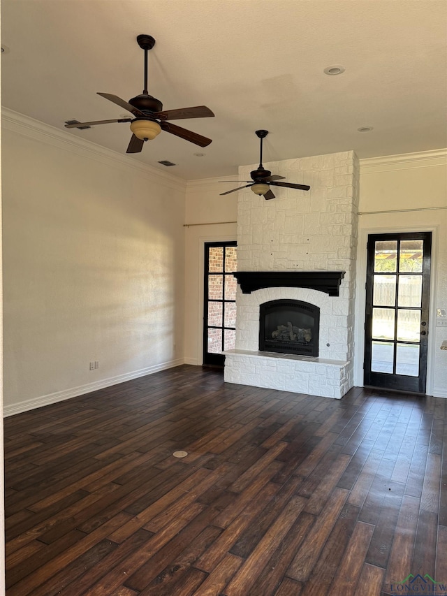 unfurnished living room with ceiling fan, crown molding, a fireplace, and dark wood-type flooring