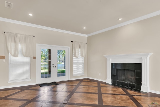 unfurnished living room featuring french doors, ornamental molding, and a tiled fireplace