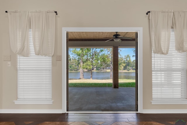 doorway to outside with ceiling fan, dark hardwood / wood-style flooring, a water view, and wooden ceiling