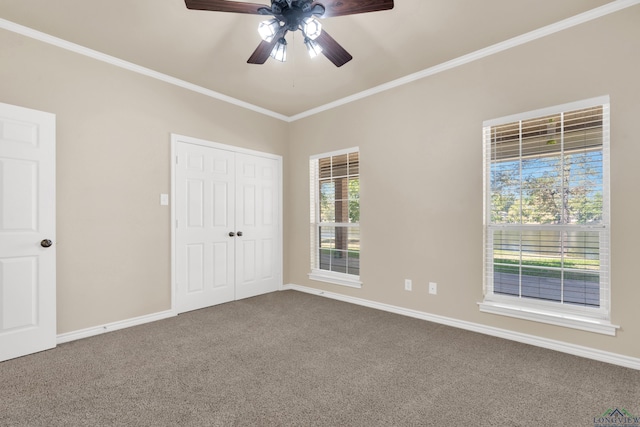 carpeted spare room with ceiling fan and crown molding