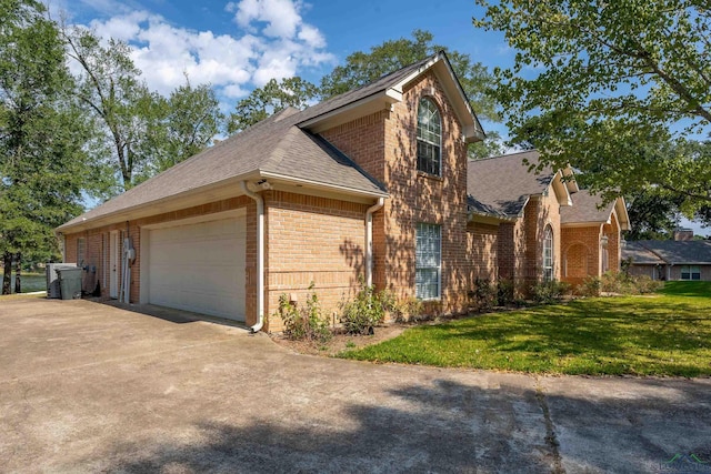 view of side of home featuring a garage and a yard