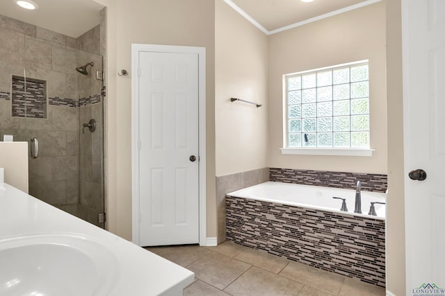 bathroom featuring plus walk in shower, tile patterned flooring, ornamental molding, and sink