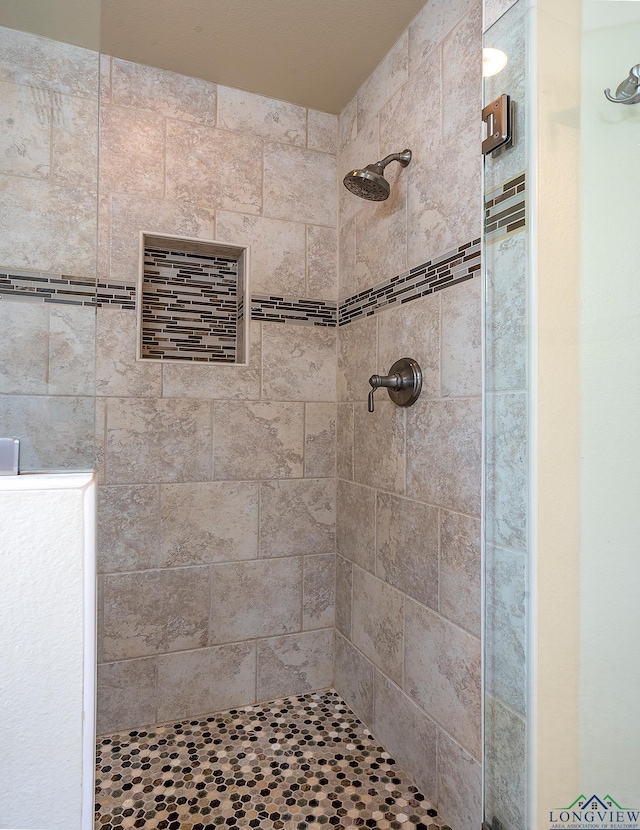 bathroom with a tile shower