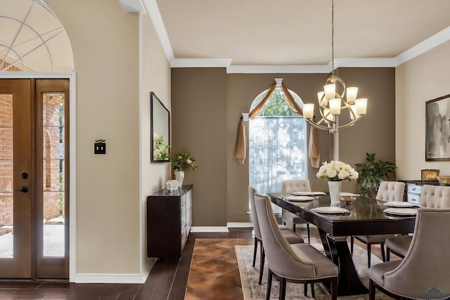 dining space with a notable chandelier, crown molding, and french doors