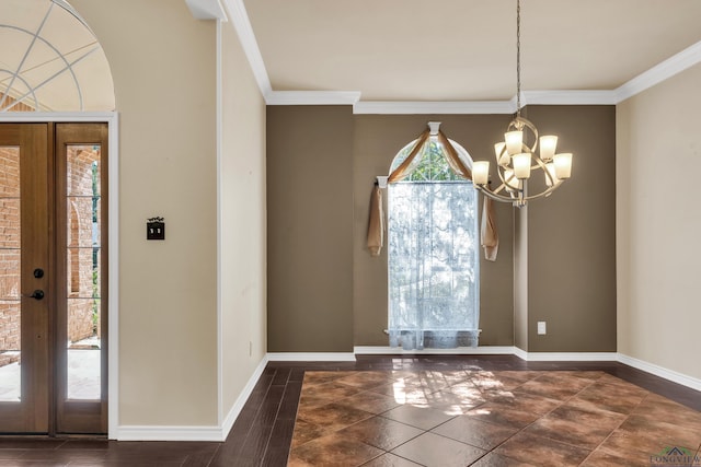 entryway featuring ornamental molding, french doors, and an inviting chandelier