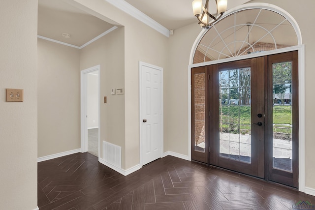 foyer entrance with a chandelier, french doors, dark parquet floors, and crown molding