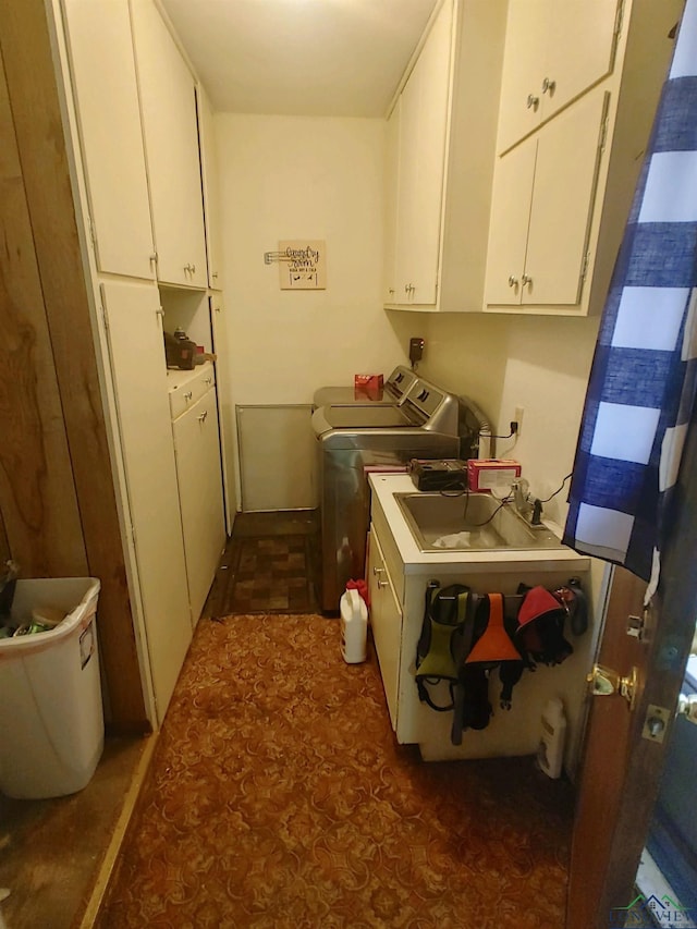 laundry area featuring washing machine and clothes dryer, sink, and cabinets