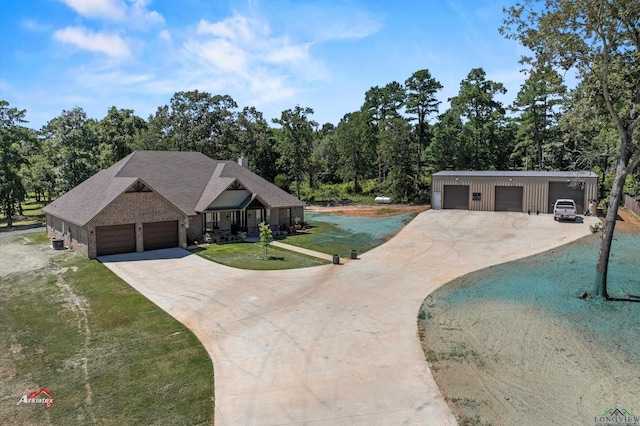 view of front of home featuring a front lawn, central AC unit, and a garage