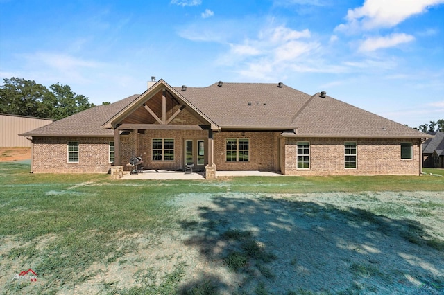 back of property featuring a lawn and a patio