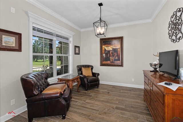 sitting room featuring crown molding and an inviting chandelier