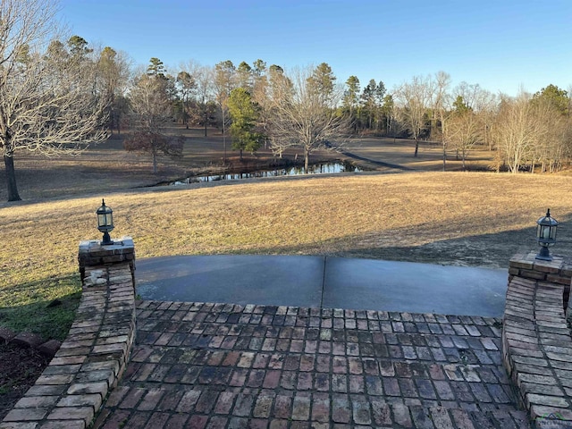 view of property's community with a lawn and a water view