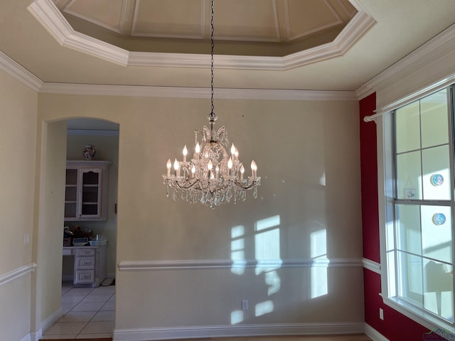 unfurnished dining area with light tile patterned flooring, crown molding, a tray ceiling, and a chandelier