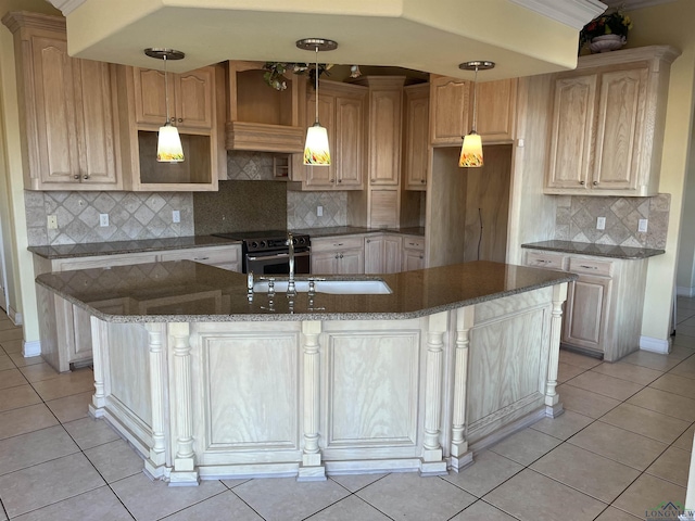 kitchen with a kitchen island with sink, light brown cabinets, light tile patterned floors, and stainless steel range with electric stovetop