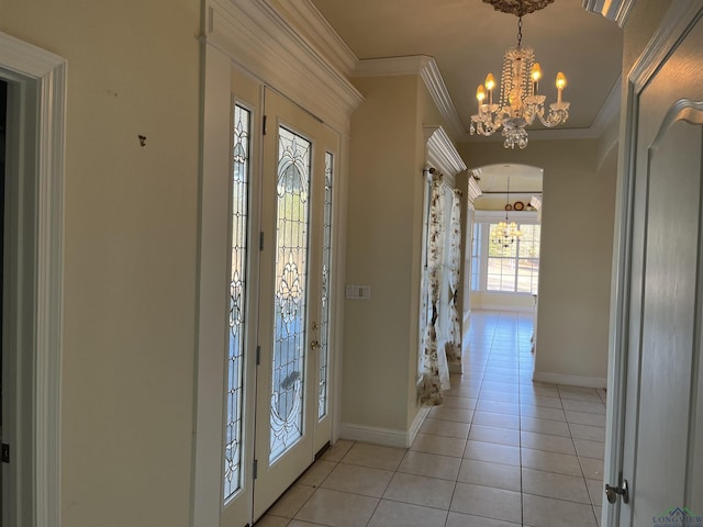 entrance foyer with crown molding, light tile patterned floors, and a chandelier