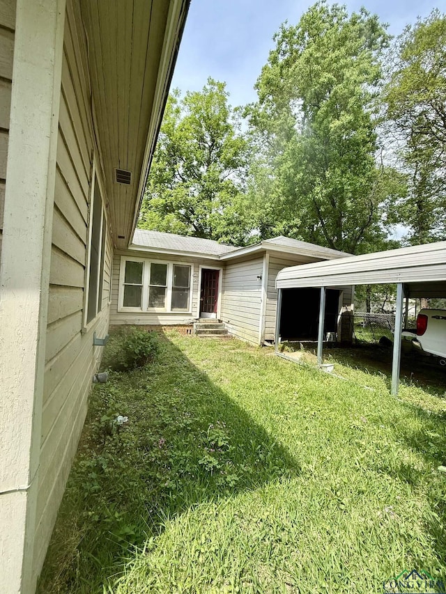 view of yard with a carport and entry steps