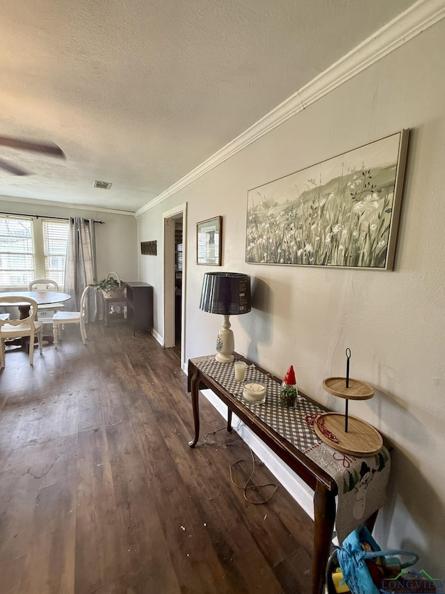 233 S Chalk St, Joaquin, TX 75954 - living area featuring wood-type flooring, ornamental molding, visible vents, baseboards, and a textured ceiling