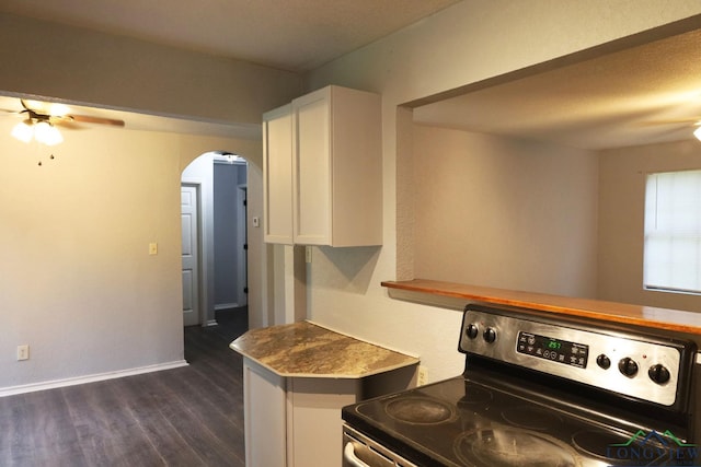 2104 Ark St, Marshall, TX 75670 - kitchen with stainless steel range with electric cooktop, arched walkways, white cabinetry, dark wood-style floors, and a ceiling fan