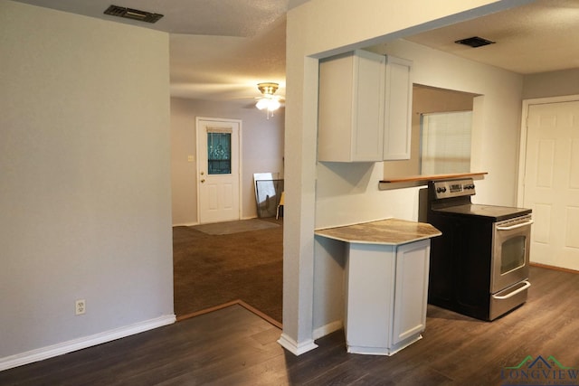 2104 Ark St, Marshall, TX 75670 - kitchen with stainless steel range with electric stovetop, white cabinets, dark wood finished floors, and a ceiling fan