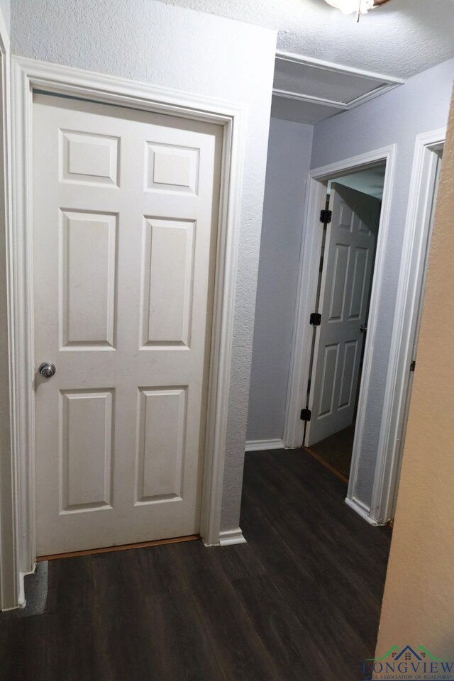 2104 Ark St, Marshall, TX 75670 - corridor featuring dark wood finished floors and a textured wall