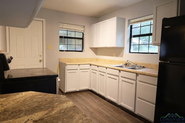 2104 Ark St, Marshall, TX 75670 - kitchen featuring black appliances, dark wood finished floors, white cabinetry, and light countertops