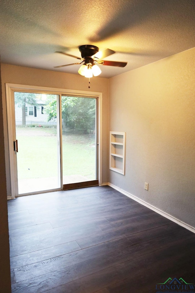 2104 Ark St, Marshall, TX 75670 - unfurnished room featuring dark wood-style flooring, ceiling fan, a textured ceiling, and built in shelves