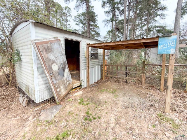 view of shed featuring fence