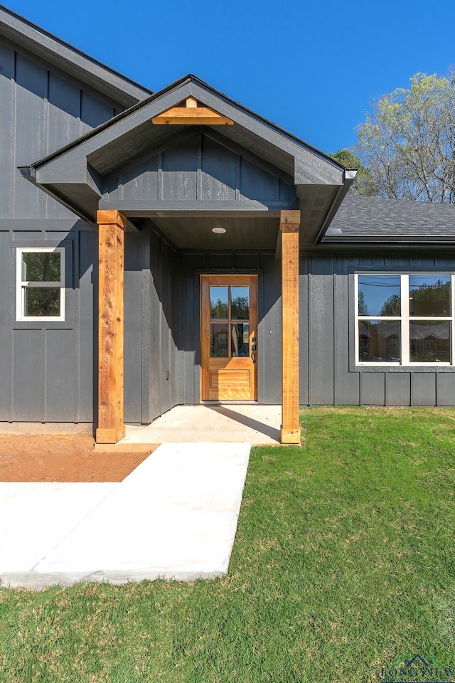 entrance to property featuring a lawn