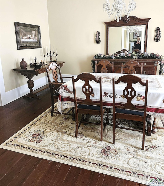 dining space with hardwood / wood-style flooring and a chandelier