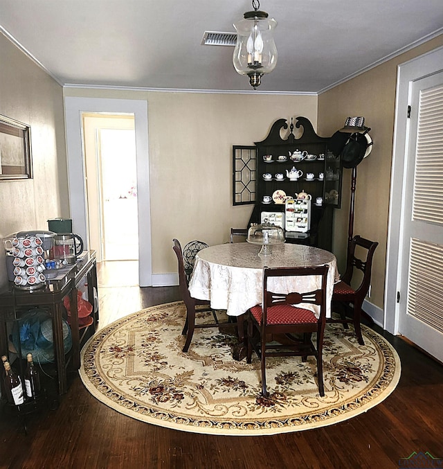 dining room with hardwood / wood-style floors and ornamental molding