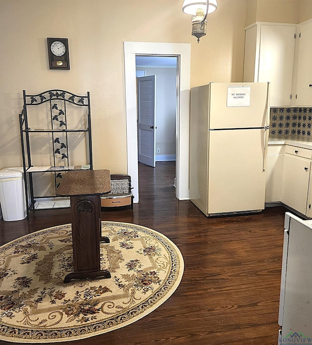 kitchen featuring backsplash, white cabinets, white fridge, and dark hardwood / wood-style floors