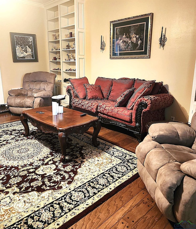 living room with wood-type flooring, built in features, and ornamental molding