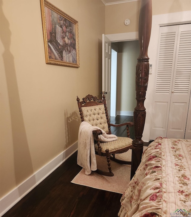 bedroom featuring dark hardwood / wood-style floors, ornamental molding, and a closet