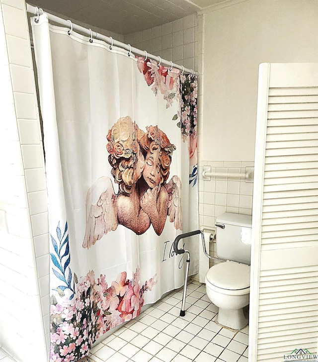 bathroom featuring tile patterned floors, tile walls, and toilet